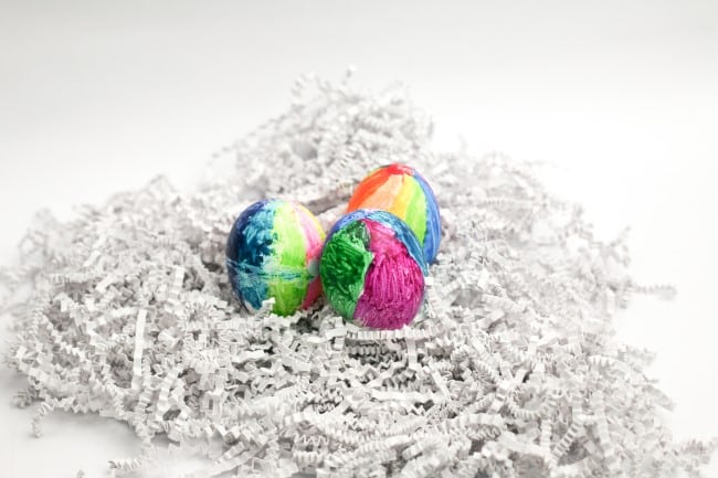 Melted Crayon Easter egg craft - Three colorful Easter eggs made with crayons nested in shredded paper