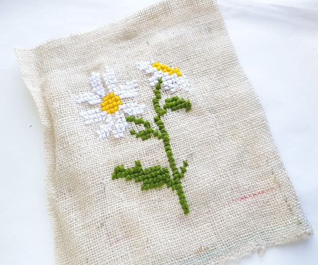 Easy Cross Stitch Pattern - two daisies with stem and leaves on burlap fabric