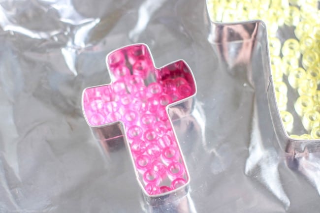 cross suncatcher melted bead idea - pink pony beads placed in cross on aluminum foil