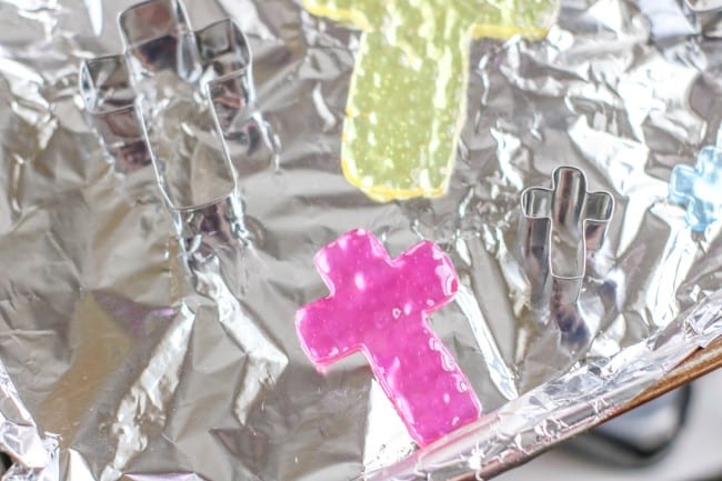 cross suncatcher melted bead idea - melted pink and yellow cross suncatchers on tray