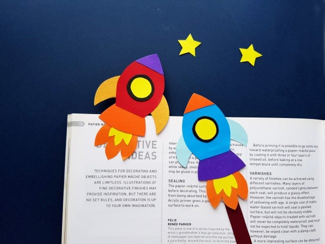Rocket Bookmark Craft - two colorful rocket bookmarks in front of a book