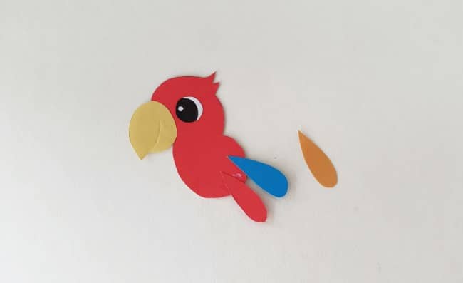 parrot paper bookmark - parrot body cutout with tail feathers being attached
