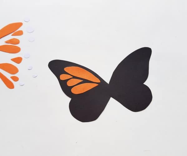 monarch butterfly craft - step two: orange cutouts being glued to black body