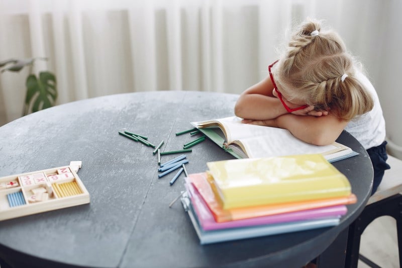 quiet time - girl sleeping at table with book beneath her