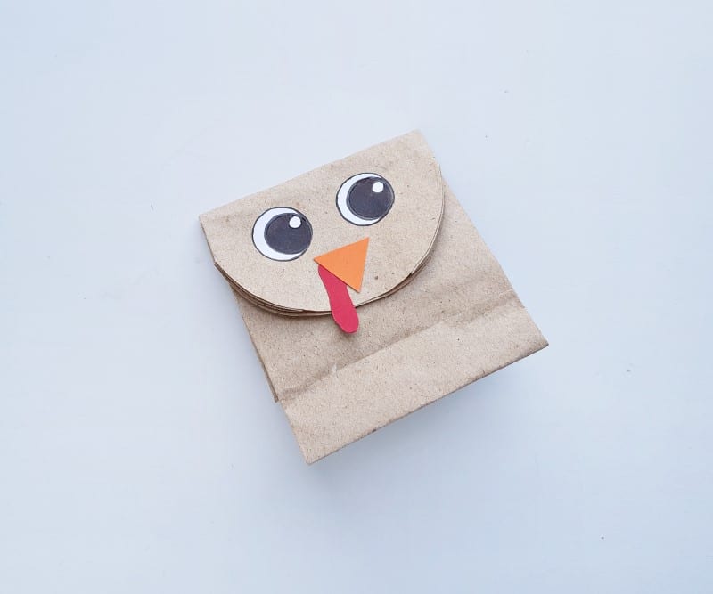 paper bag turkey - step three with eyes, beak and wattle glued to paper bag