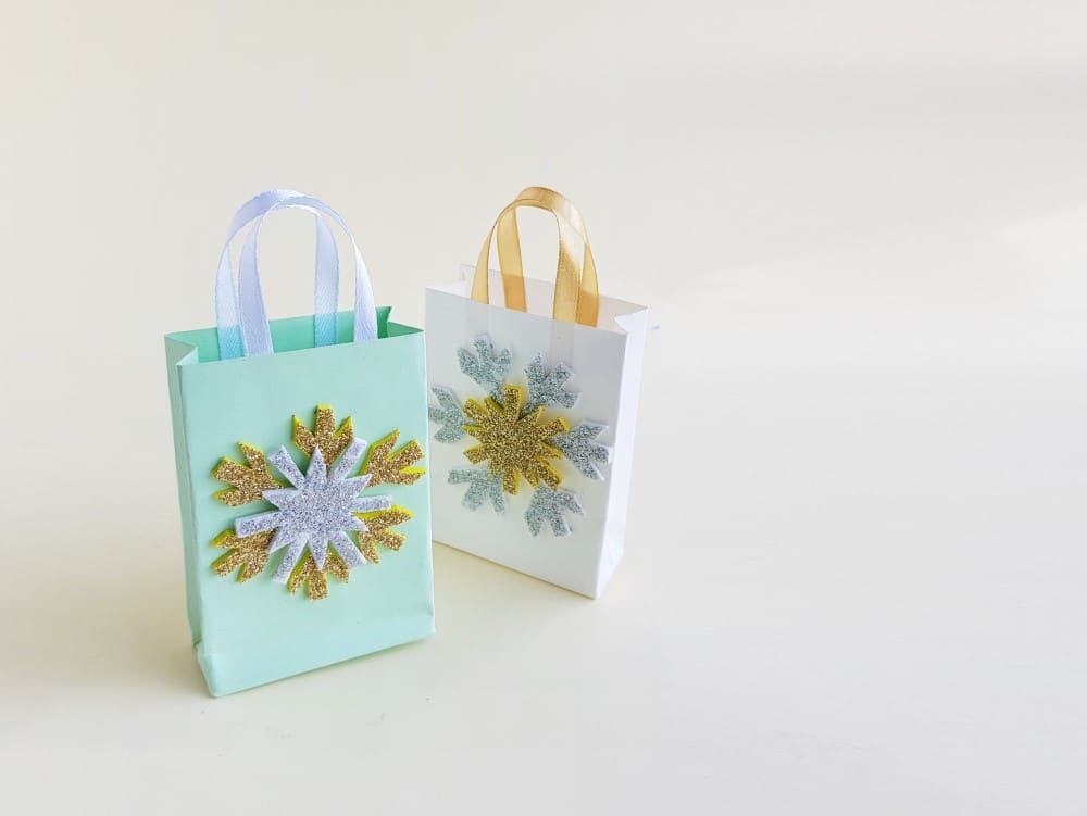 two snowflake paper bags, one blue and one white